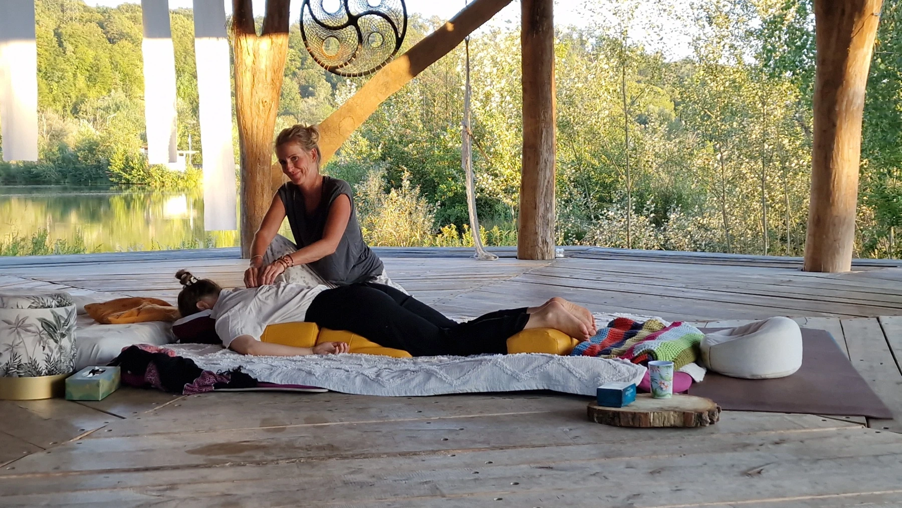 Daniela bei einer Shiatsu-Behandlung an der Seebühne mit Blick ins Grüne und aufs Wasser